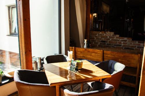 a dining room with a wooden table and chairs at Penzión Furkotka in Štrbské Pleso