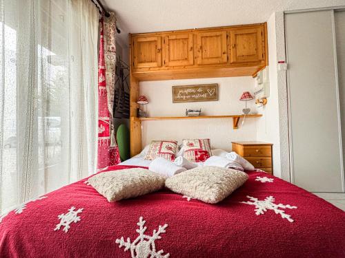 - un lit rouge avec des oreillers recouverts de neige dans l'établissement Charmant Studio Avec Terrasse By TerraAlpina, à Saint-Gervais-les-Bains
