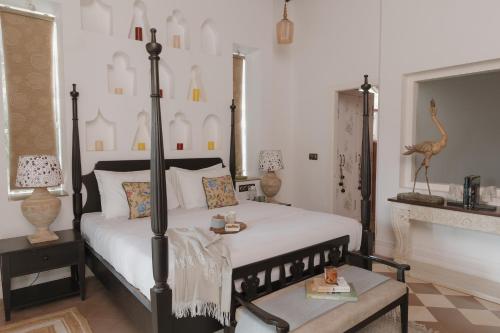 a bedroom with a black and white bed and a fireplace at ELIVAAS Maison 10 - Luxe 4 BHK Villa With Pvt Pool, Garden & Portuguese Charm in Siolim