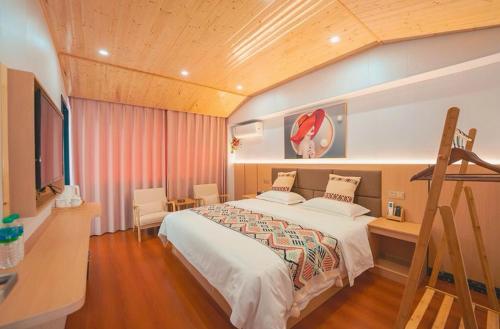 a bedroom with a large bed and a desk at Zhangjiajie RuiYuan Hotel - Zhangjiajie West Railway Station in Zhangjiajie
