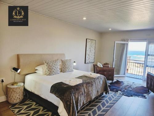 ランバーツ・ベイにあるLambertsbay Beachfrontのベッドルーム1室(ベッド1台付)、海を望むバルコニーが備わります。