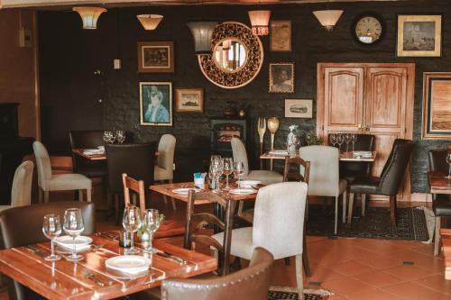 a restaurant with tables and chairs in a room at Honeywood Forest Lodge in Port Shepstone