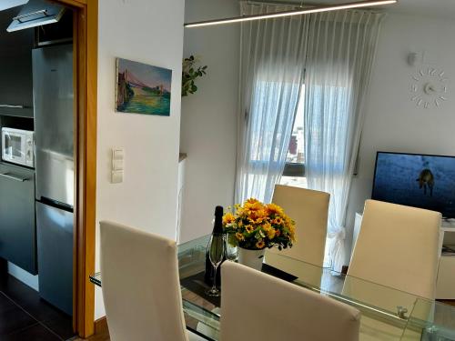 a dining room with a glass table and chairs at Lo balconet del Delta. Àtic-dúplex vacacional. in Amposta