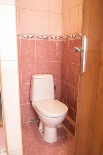 a bathroom with a toilet in a tiled room at Penzión Furkotka in Štrbské Pleso
