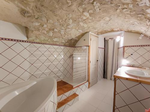 une salle de bain avec une baignoire et un lavabo dans l'établissement La Terrasse de la Citadelle, à Sisteron