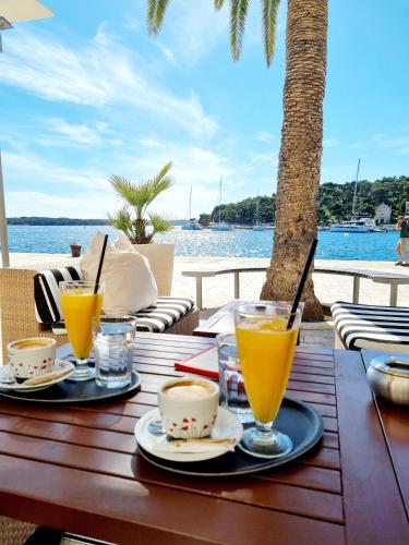 a wooden table with two glasses of orange juice at Vila Santa Maria Hvar with jacuzzi in Jelsa