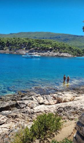 two people standing in the water at a beach at Vila Santa Maria Hvar with jacuzzi in Jelsa