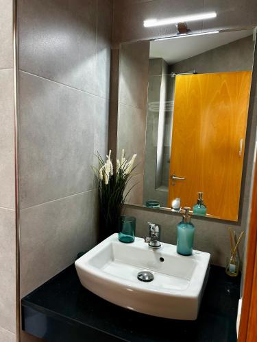 a bathroom with a sink and a mirror at Lo balconet del Delta. Àtic-dúplex vacacional. in Amposta
