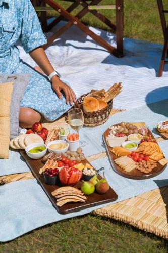 a woman sitting on a blanket with a tray of food at Organic Village Retreat in Hundar