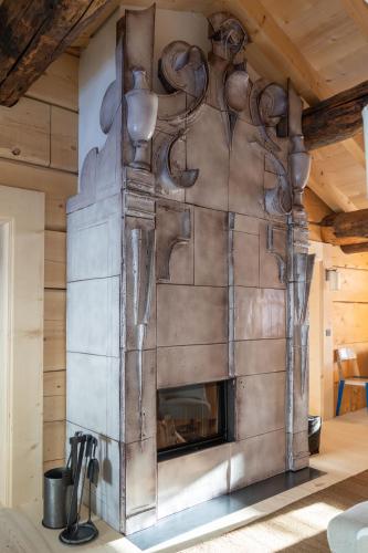 a stone fireplace in a room with a wooden ceiling at Chalet Sonnenhof Lech in Lech am Arlberg