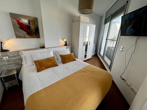 a bedroom with a large bed with two pillows at Lo balconet del Delta. Àtic-dúplex vacacional. in Amposta