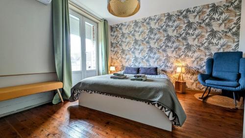 a bedroom with a bed and a blue chair at Maison cosy - Centre - Perche in Tourouvre