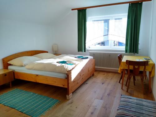 a bedroom with a bed and a table and a window at Privatzimmer mit Küche in Au bei Turnau in Göriach
