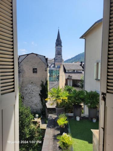 a view from an apartment balcony of a courtyard with plants at grand T4 proche sanctuaires in Lourdes