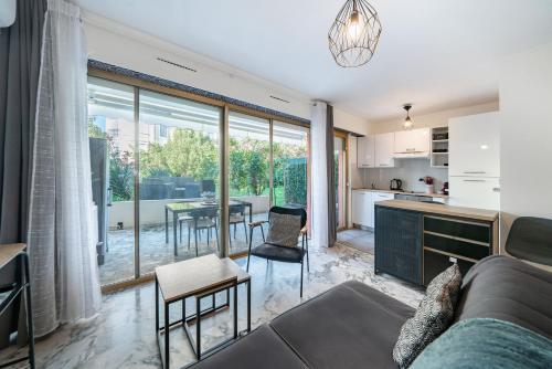 une cuisine et un salon avec un canapé et une table dans l'établissement Studio avec terrasse et jardin arboré - 5 min hypercentre Cannes, à Cannes