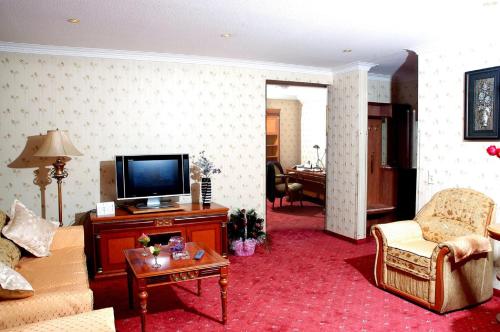 a living room with a tv and a couch and a table at Narantuul Hotel in Ulaanbaatar