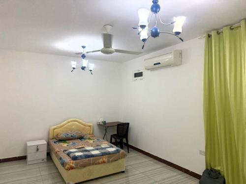 a bedroom with a bed and a table and a ceiling at 1 Separate Bedroom and Attached Bathroom in a shared apartment in Muscat