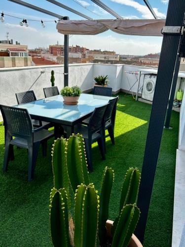 a patio with a table and chairs and cactus at Lo balconet del Delta. Àtic-dúplex vacacional. in Amposta
