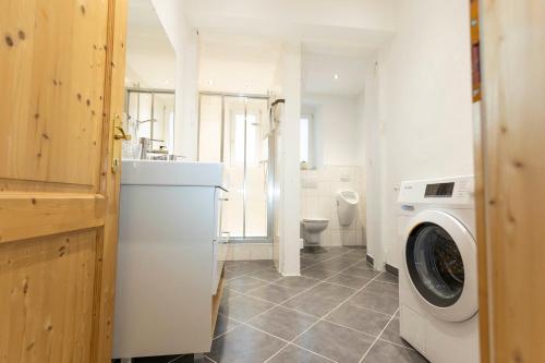 a bathroom with a washing machine and a toilet at Seebühnenblick in Seeham