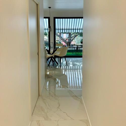 - un couloir avec un sol en marbre et une vue sur une salle à manger dans l'établissement Le Soleil Tropezien, Somptueux 2 pièces rénové, Terrasse, Centre, Vue Mer, Menton, à Menton