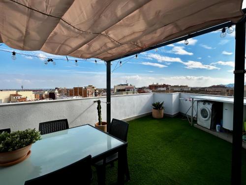 a patio with a table and chairs on a roof at Lo balconet del Delta. Àtic-dúplex vacacional. in Amposta