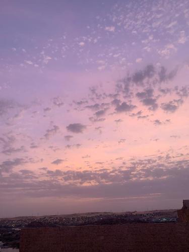 a cloudy sky with a city in the distance at king kassem nubian guest house in Aswan