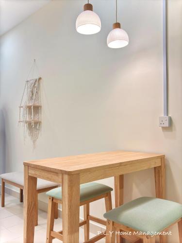 a dining room table with two lights and two chairs at Muji Ipoh Falim Free Parking & Free Netflix in Ipoh