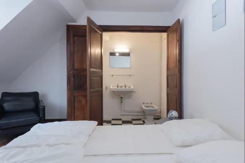 a bedroom with a bed and a bathroom with a sink at La Maison Bleue, coeur de Barèges ski et randonnée in Barèges