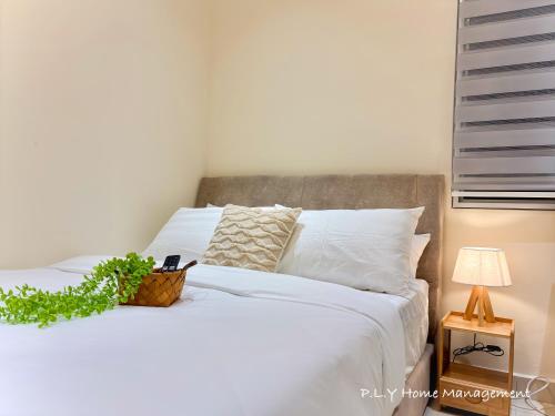 a bedroom with a white bed with a plant on it at Muji Ipoh Falim Free Parking & Free Netflix in Ipoh