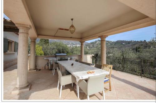 un patio avec une table et des chaises sur un balcon dans l'établissement Domaine d ock en bourg, à Grasse