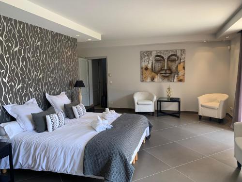 une chambre avec un grand lit avec des draps blancs dans l'établissement Domaine d ock en bourg, à Grasse