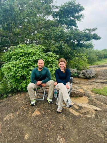 a man and woman sitting in chairs on a rock at Wild River Side in Udawalawe