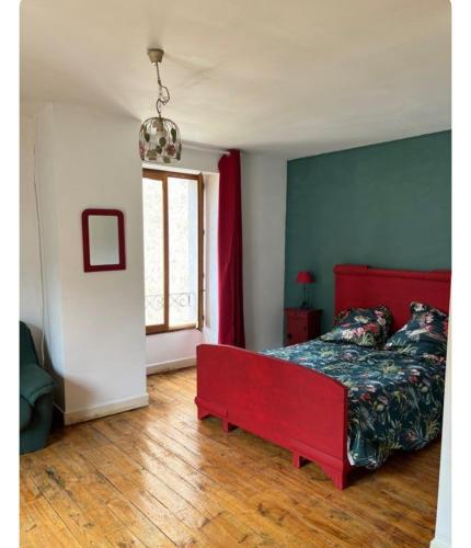 - une chambre avec un lit rouge et une fenêtre dans l'établissement La Maison du Foirail, à Aurillac