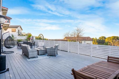 a deck with chairs and a table and a fence at LUX Retreat - Best Views - All Amenities - Central in Lomita