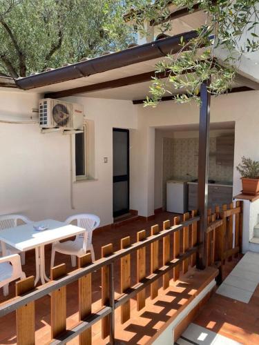 a wooden deck with a table and chairs on it at Residence Punta Cilento in Pisciotta