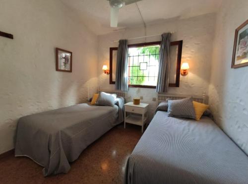 a bedroom with two beds and a window at lovely bungalow with parking in Playa del Ingles