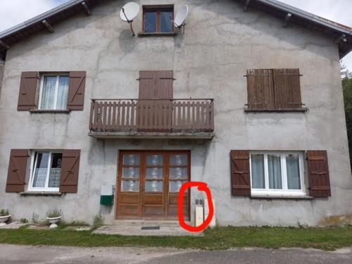 un cercle rouge est assis devant une maison dans l'établissement Les Coteaux de Chalain, à Doucier