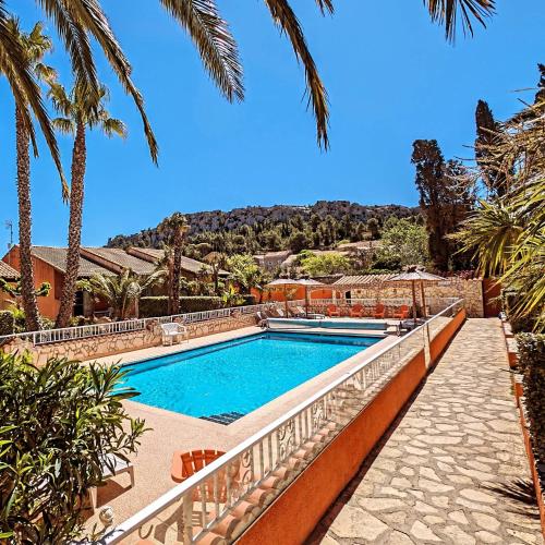 - une piscine dans une villa avec des palmiers dans l'établissement Gite la Capelle Roquefort des Corbières Sigean Narbonne Aude, à Roquefort-des-Corbières
