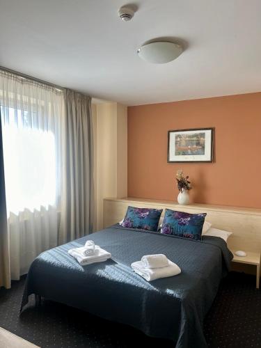 a hotel room with a bed with towels on it at Hotel Pacific in Timişoara
