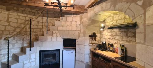 a kitchen with a white refrigerator and a stove at Moulin à vent romantique et atypique en Touraine in Seuilly