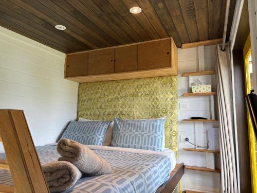 马拉库塔Ocean Breeze Tiny House - Ocean and Lake View的小屋内的一张床位,设有木制天花板
