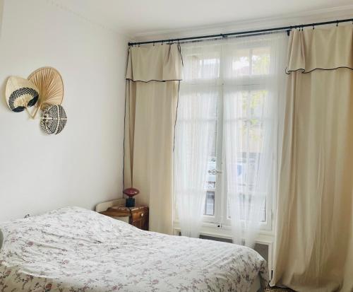 une chambre avec un lit et une grande fenêtre dans l'établissement Villa Le Palmier, à Montpellier