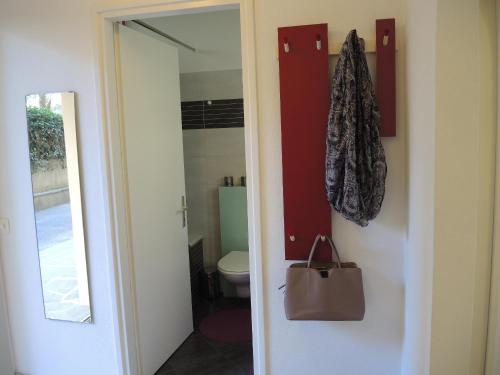 a bathroom with a toilet and a purse next to a door at Sibylle by Fewotessin in Locarno
