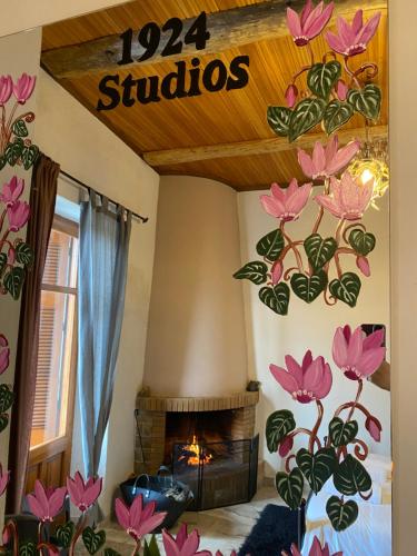 a room with a fireplace and a sign that reads subos at 1924 Studios 2 in Áyios Pétros