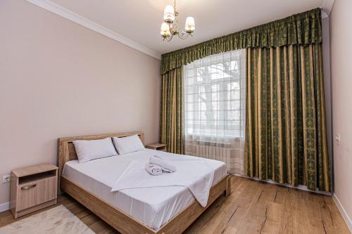 a bedroom with a bed and a window at Просторная 3х комнатная квартира в центре Алматы in Almaty