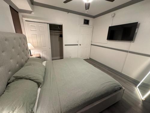 a bedroom with a bed and a flat screen tv at CityBreak JAX in Jacksonville