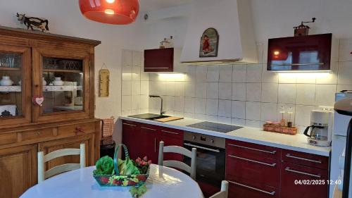 - une cuisine avec des placards rouges et une table dans l'établissement T2 de 55m avec jardin et parking privatifs, à Aix-les-Bains