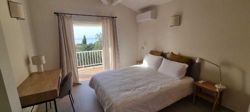 une chambre avec un lit et une grande fenêtre dans l'établissement Maison de standing avec piscine vue mer Corse du sud de 6 à 14 personnes 7 chambres, à Coti-Chiavari