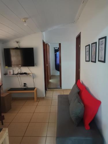 a living room with a couch and a flat screen tv at casa Amarela in Tamoios