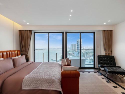 a bedroom with a large bed and a large window at Merton Holiday Inn in Phnom Penh